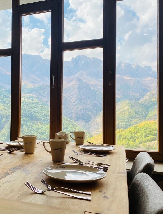 Pencere önünde kahvaltı için kurulmuş restoran masaları